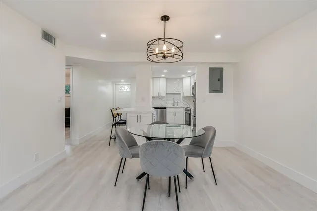 a view of a dining room with furniture wooden floor and a chandelier