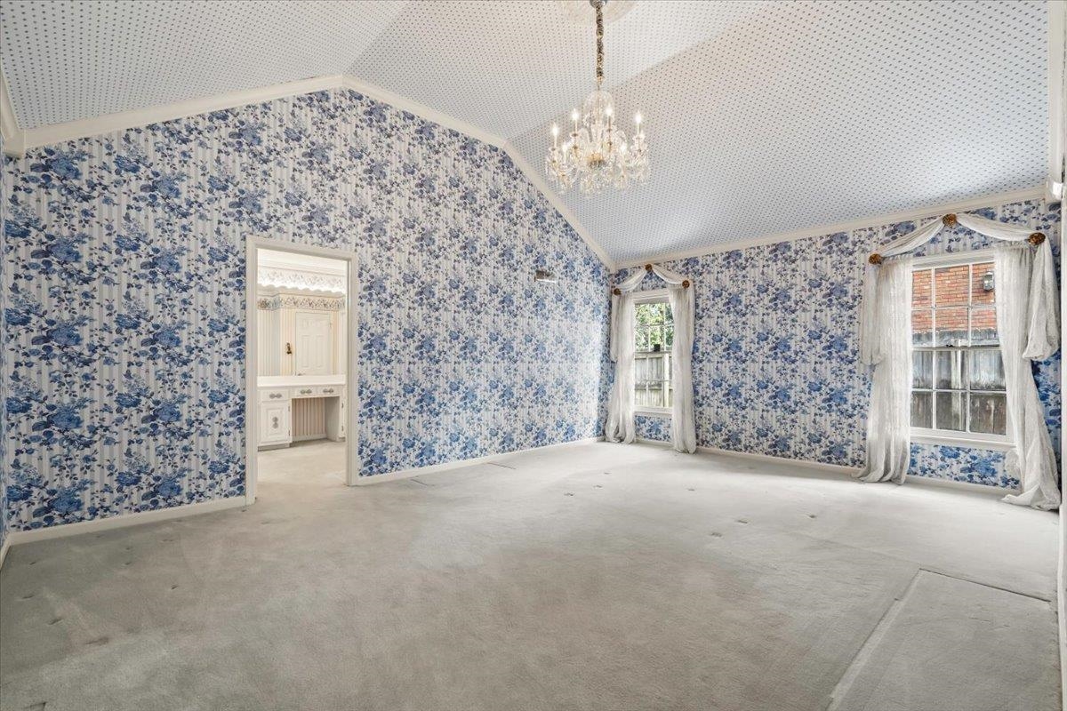 5710 Herald Square Memphis, TN 38120 - Photo 20 of 31 Carpeted spare room featuring lofted ceiling, ornamental molding, and an inviting chandelier