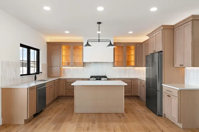 a kitchen with stainless steel appliances granite countertop a sink stove and refrigerator