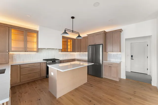 a kitchen with stainless steel appliances granite countertop a stove a refrigerator and a sink