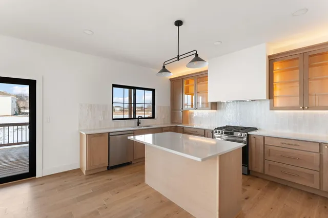 a kitchen that has a sink a window and stainless steel appliances
