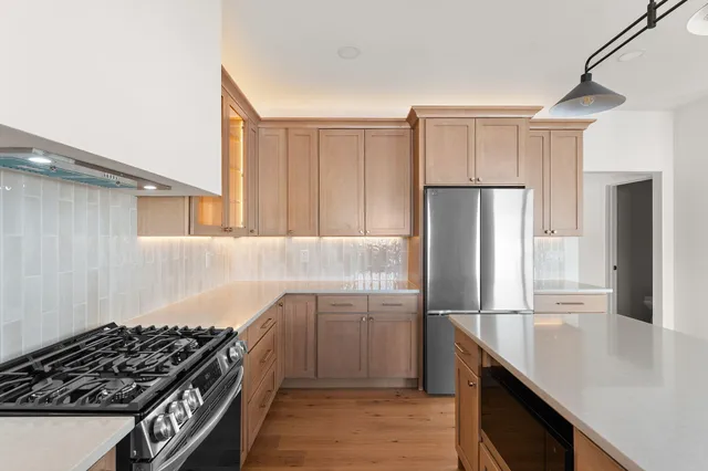 a kitchen with kitchen island stainless steel appliances a sink stove and refrigerator