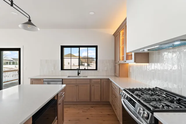 a kitchen with stainless steel appliances a sink stove and cabinets