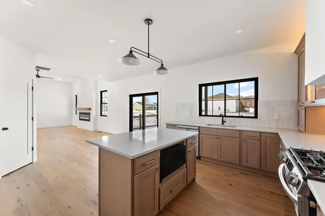 a open kitchen with stainless steel appliances granite countertop a sink stove and refrigerator