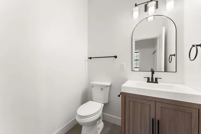 a bathroom with a sink a toilet and a mirror