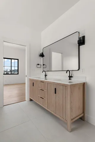 a bathroom with a double vanity sink a mirror and a bathtub