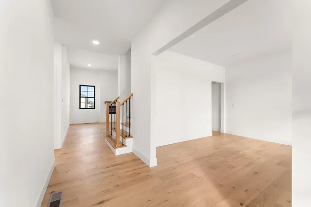 a view of a hallway with wooden floor and stairs