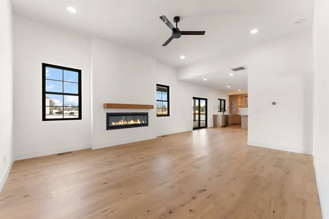 an empty room with windows and ceiling fan