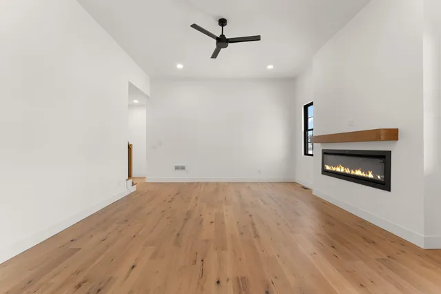 an empty room with a fireplace and wooden floor