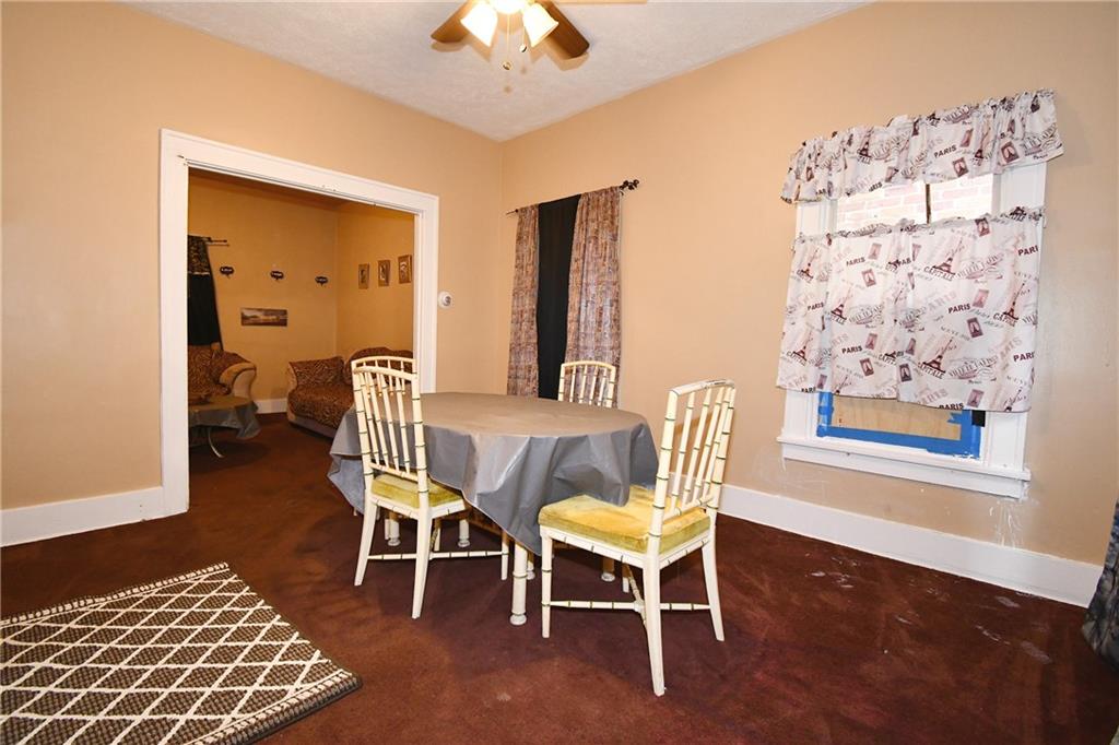 108 Locust Street Pittsburgh, PA 15210 - Photo 29 of 36 a dining room with wooden floor and a chandelier