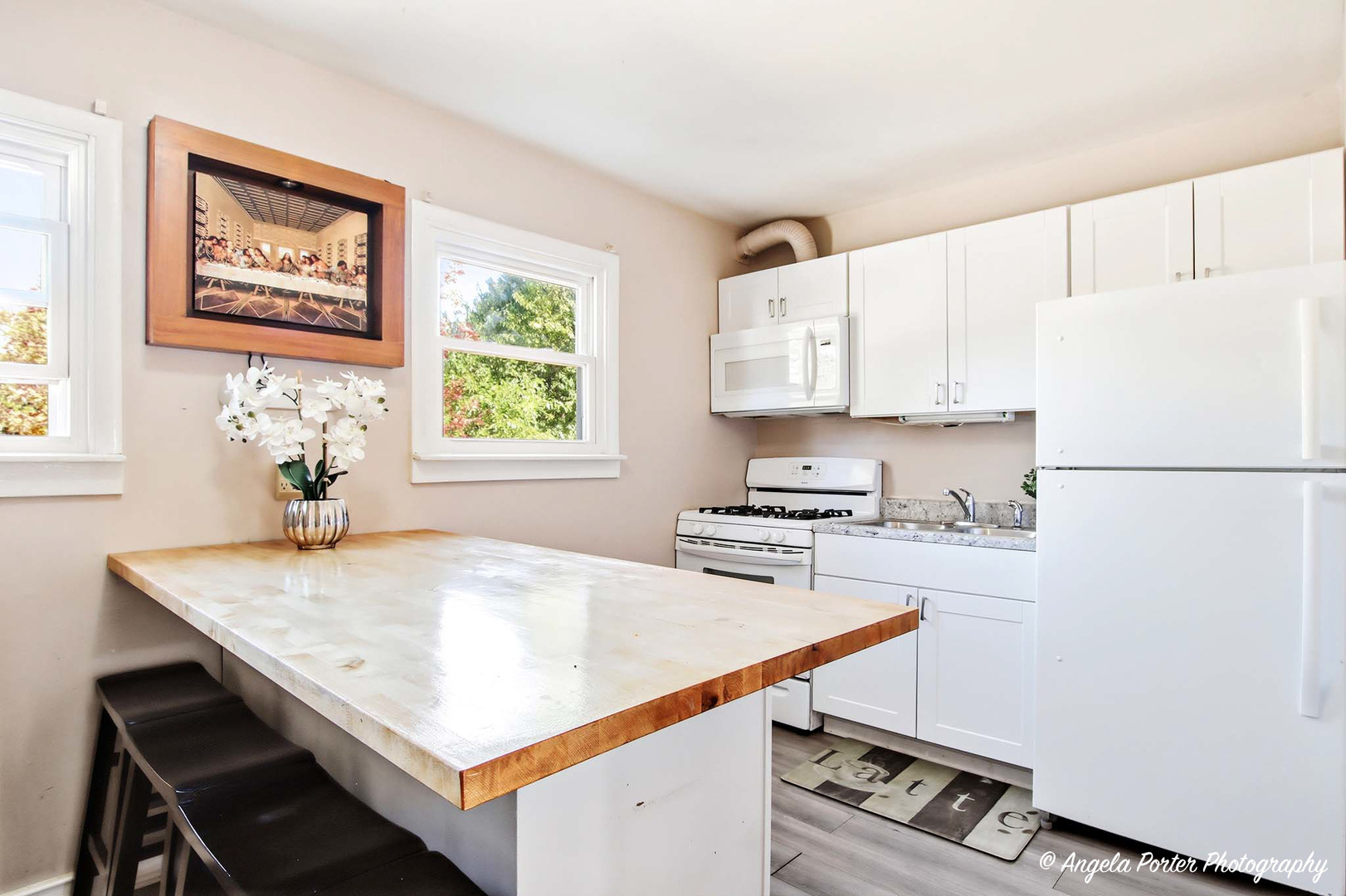 1612 Whitney Street Waukegan, IL 60087 - Photo 7 of 20 a kitchen with stainless steel appliances a stove a sink a refrigerator white cabinets and wooden floor