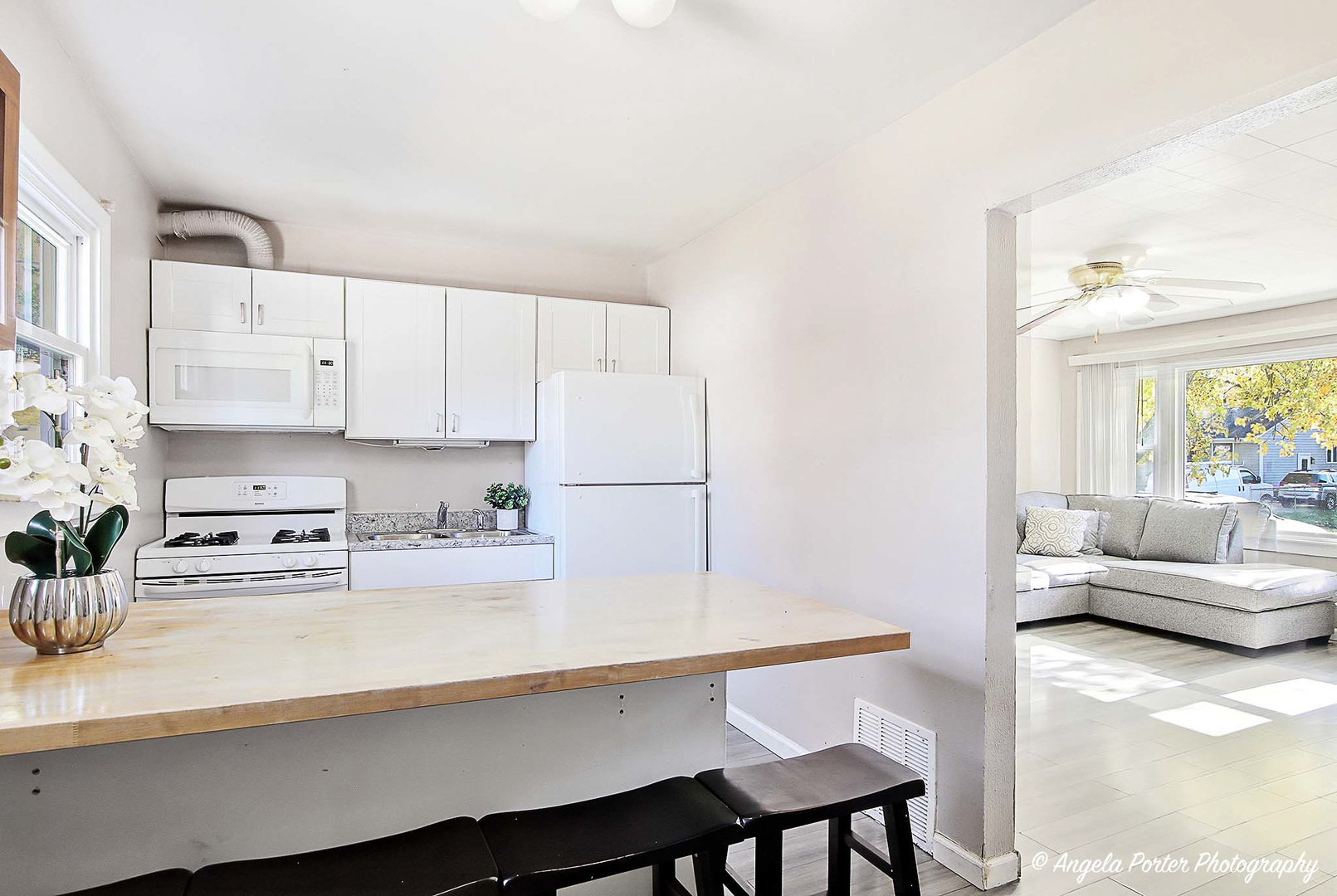 1612 Whitney Street Waukegan, IL 60087 - Photo 8 of 20 a kitchen with stainless steel appliances a sink a stove a refrigerator white cabinets and wooden floor