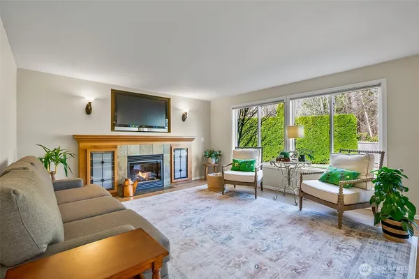 a living room with furniture a large window and a fireplace