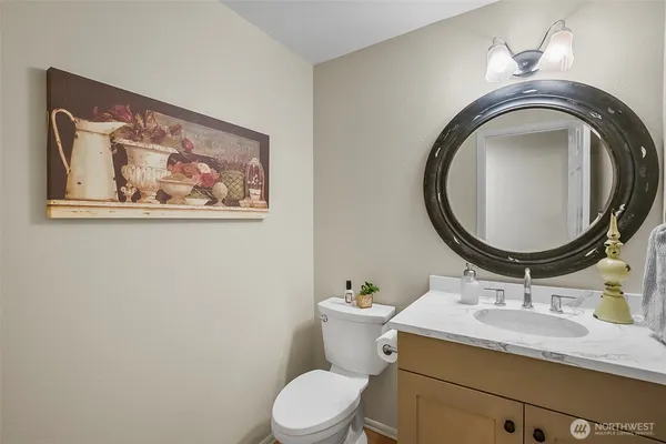 a bathroom with a granite countertop toilet a sink and a mirror