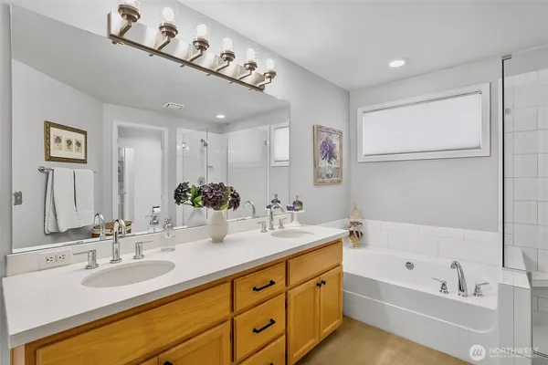a bathroom with a tub sink and mirror