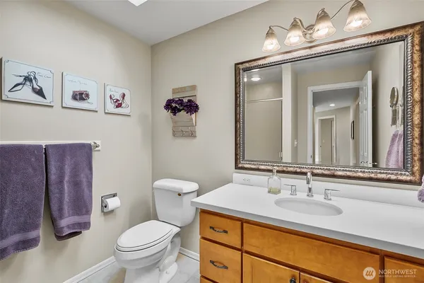 a bathroom with a granite countertop toilet sink and mirror
