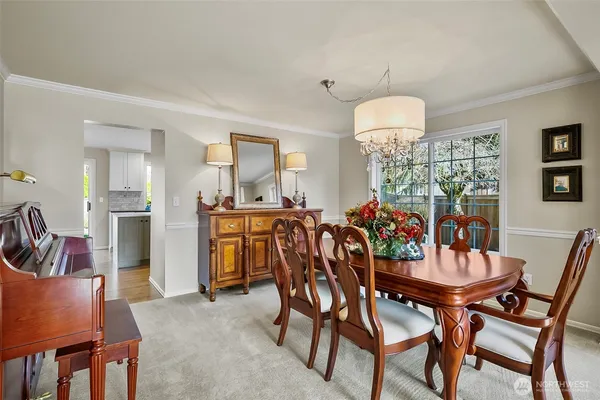 a view of a dining room with furniture and chandelier