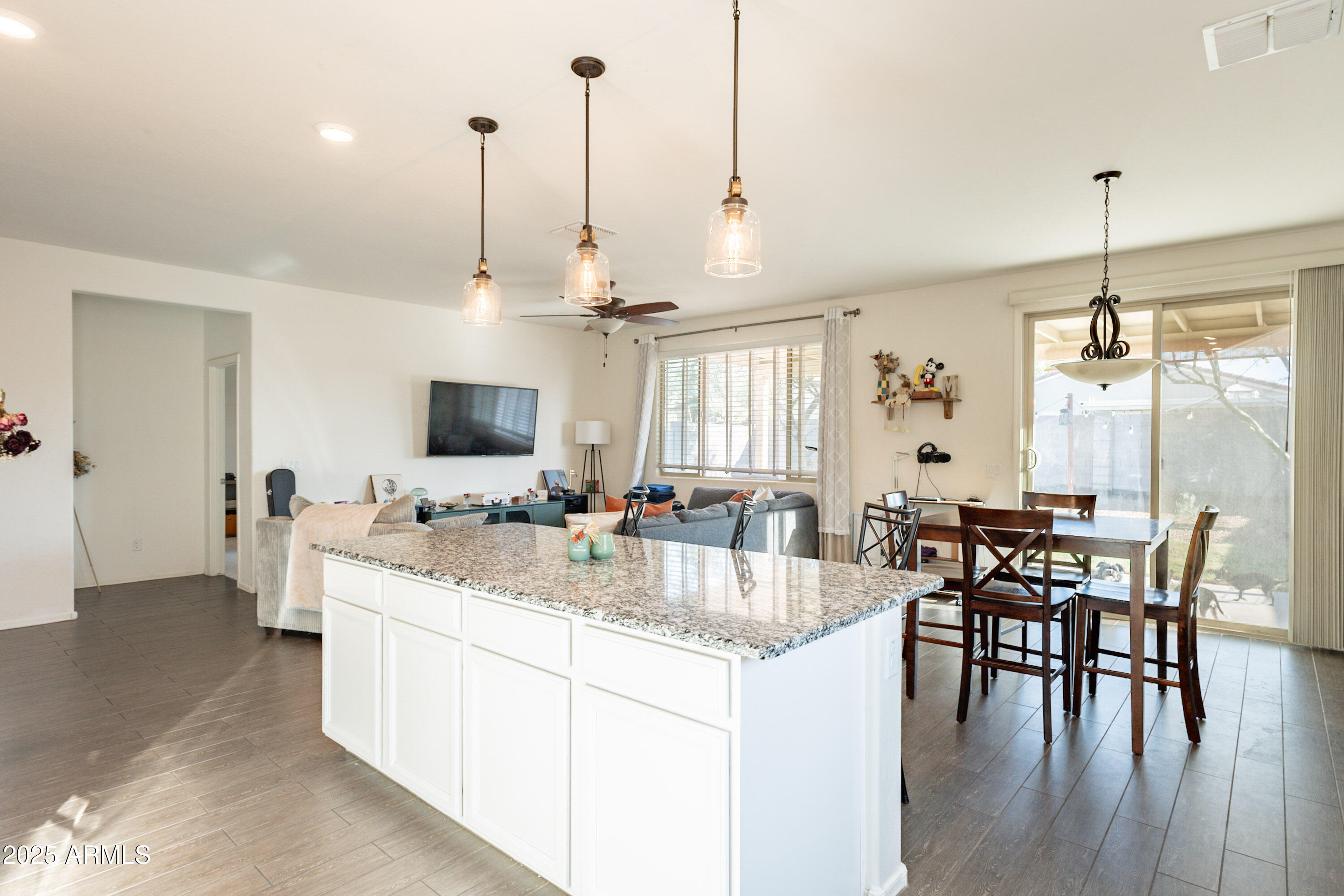 1813 Grenadine Road Phoenix, AZ 85040 - Photo 11 of 33 a large kitchen with kitchen island a dining table chairs and a wooden floor