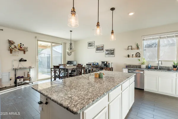 a large kitchen with kitchen island a dining table chairs and a wooden floor