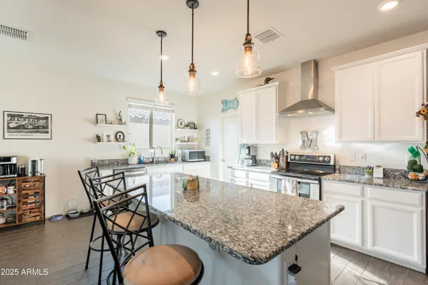 a kitchen with stainless steel appliances granite countertop a sink a stove cabinets and wooden floor