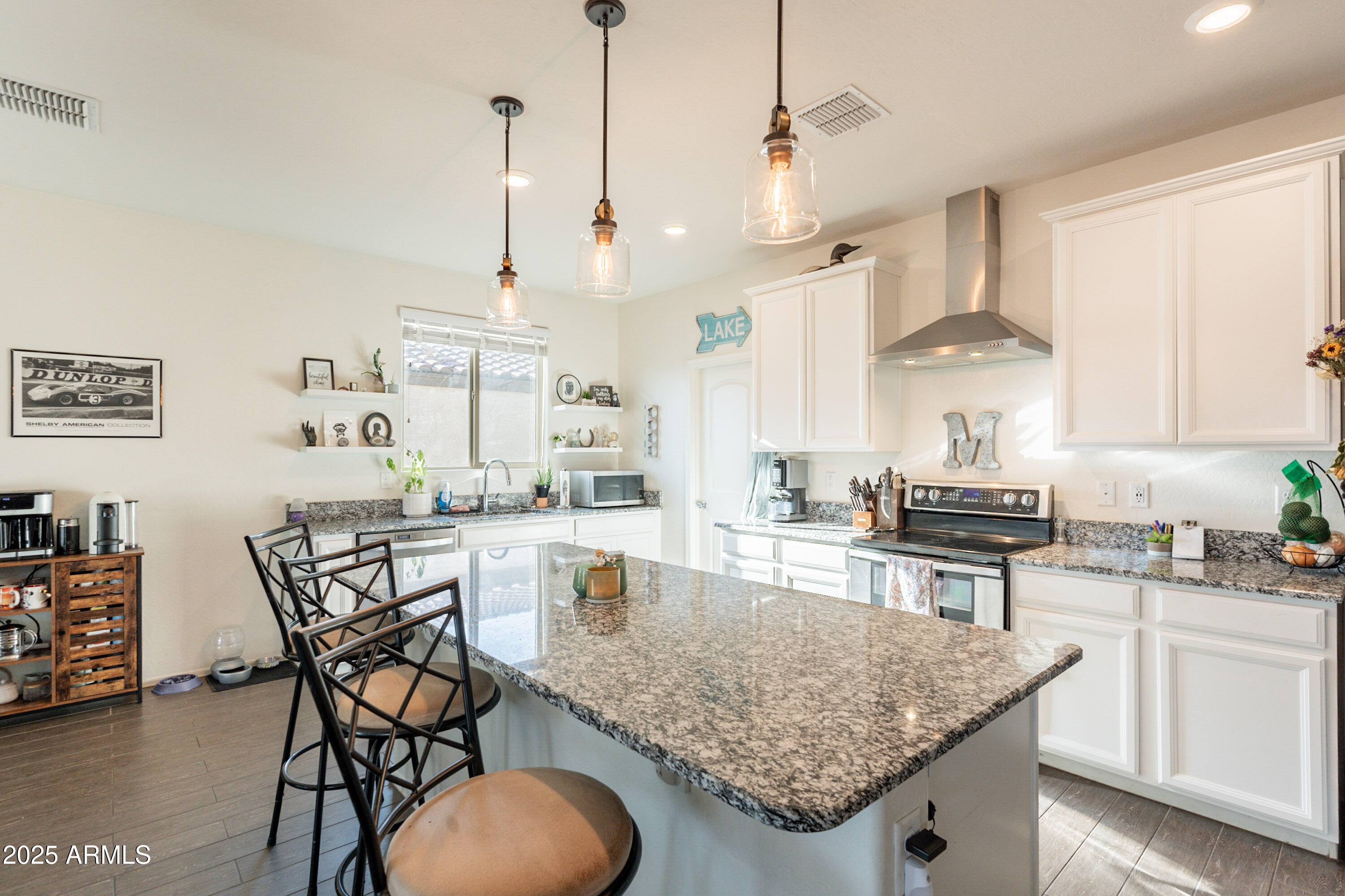 1813 Grenadine Road Phoenix, AZ 85040 - Photo 14 of 33 a kitchen with stainless steel appliances granite countertop wooden cabinets a stove a sink a dining table and chairs