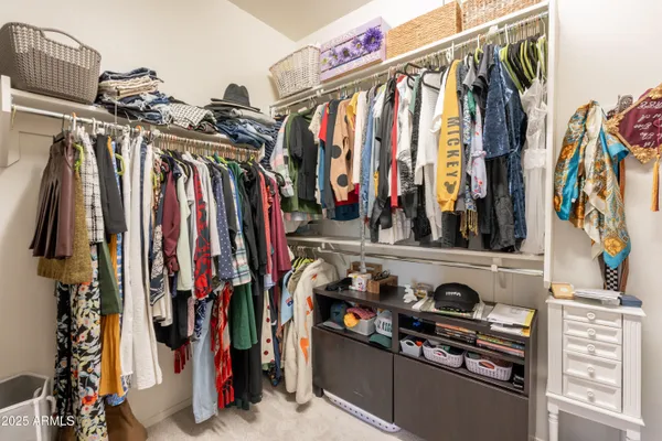 a view of walk in closet with clothes and shoes
