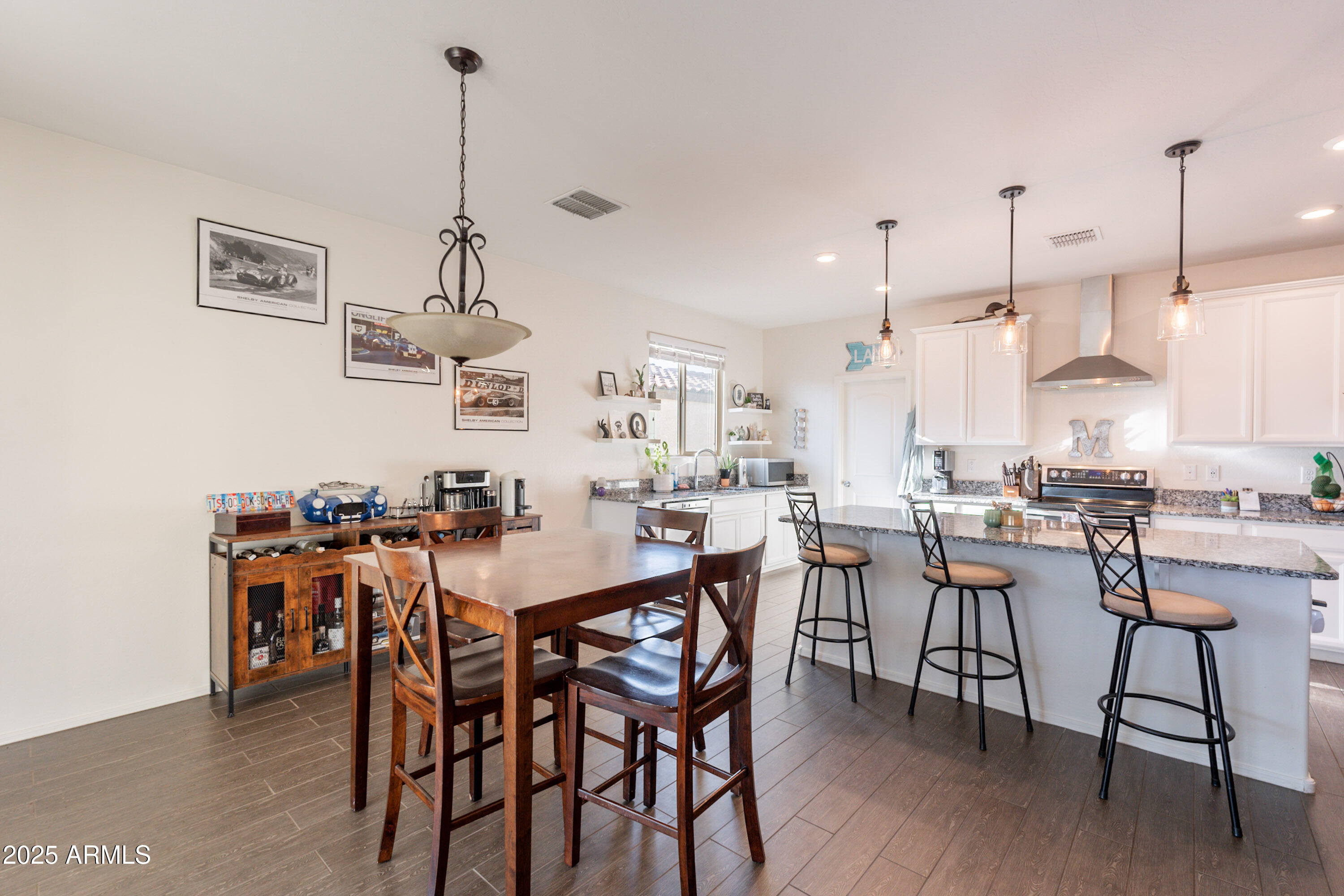 1813 Grenadine Road Phoenix, AZ 85040 - Photo 7 of 33 a view of a dining room and livingroom with furniture wooden floor a rug a chandelier