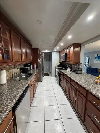 a large kitchen with granite countertop lots of counter space stainless steel appliances and cabinets