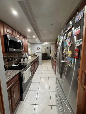 a kitchen with stainless steel appliances granite countertop a refrigerator a stove and a sink