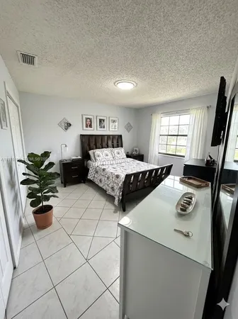 a bedroom with a bed and a potted plant