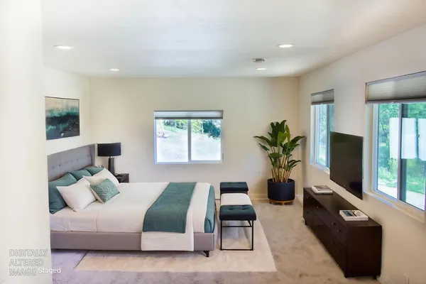 a bedroom with a bed and a potted plant