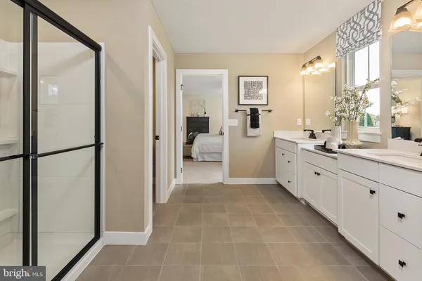 a large white bathroom with a double vanity sink a mirror and a bathtub