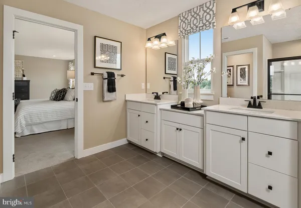 a spacious en suite bathroom with double sink and a mirror