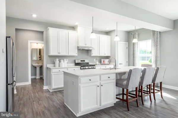 a kitchen with white cabinets stove and refrigerator