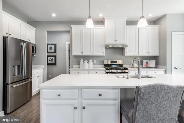 a kitchen with kitchen island white cabinets and stainless steel appliances