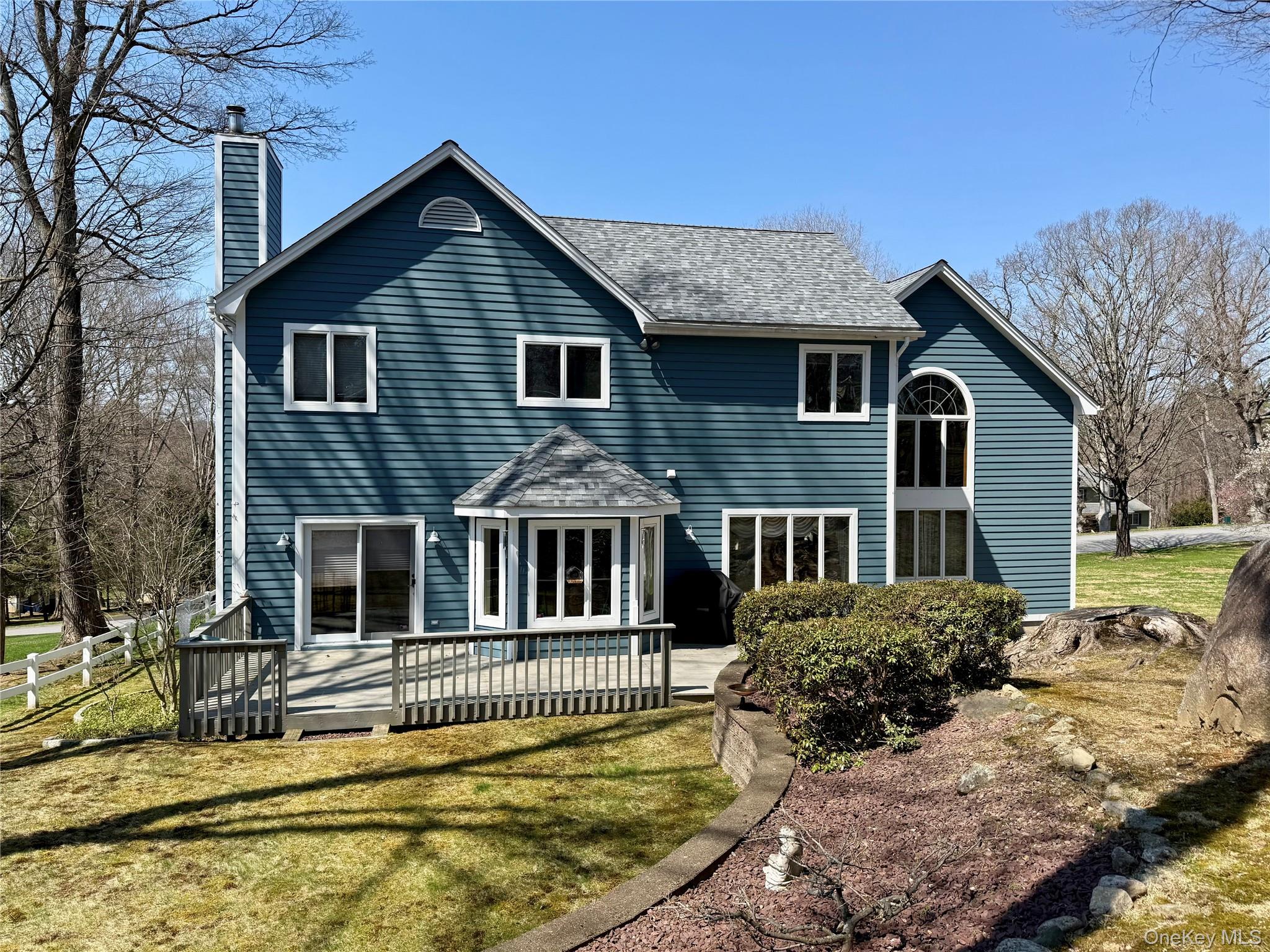 1 Ridge Court Carmel, NY 10512 - Photo 2 of 2 Private backyard setting with a large deck and sliding glass doors from the family room, perfect for seamless indoor-outdoor living and entertaining.