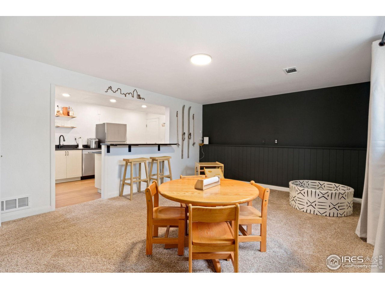 2600 Avocet Road Fort Collins, CO 80526 - Photo 13 of 26 Lower level featuring a full bar/kitchenette including soft close cabinetry an oversized stainless steel sink, dishwasher, refrigerator and custom shiplap wall fit for a movie theatre.