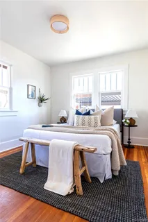 a spacious bedroom with a bed and wooden floor