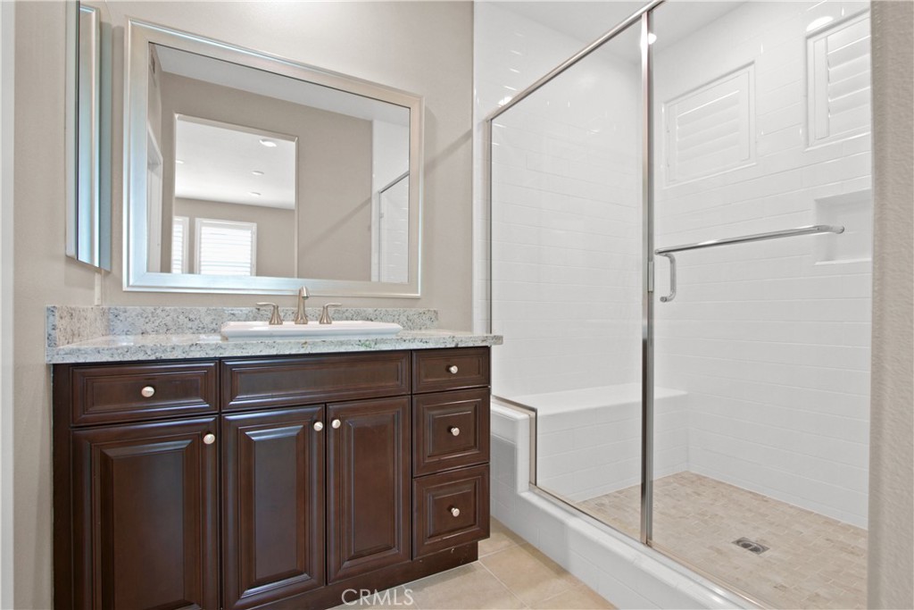 270 Radial Irvine, CA 92618 - Photo 17 of 36 a bathroom with a granite countertop sink a mirror and a shower
