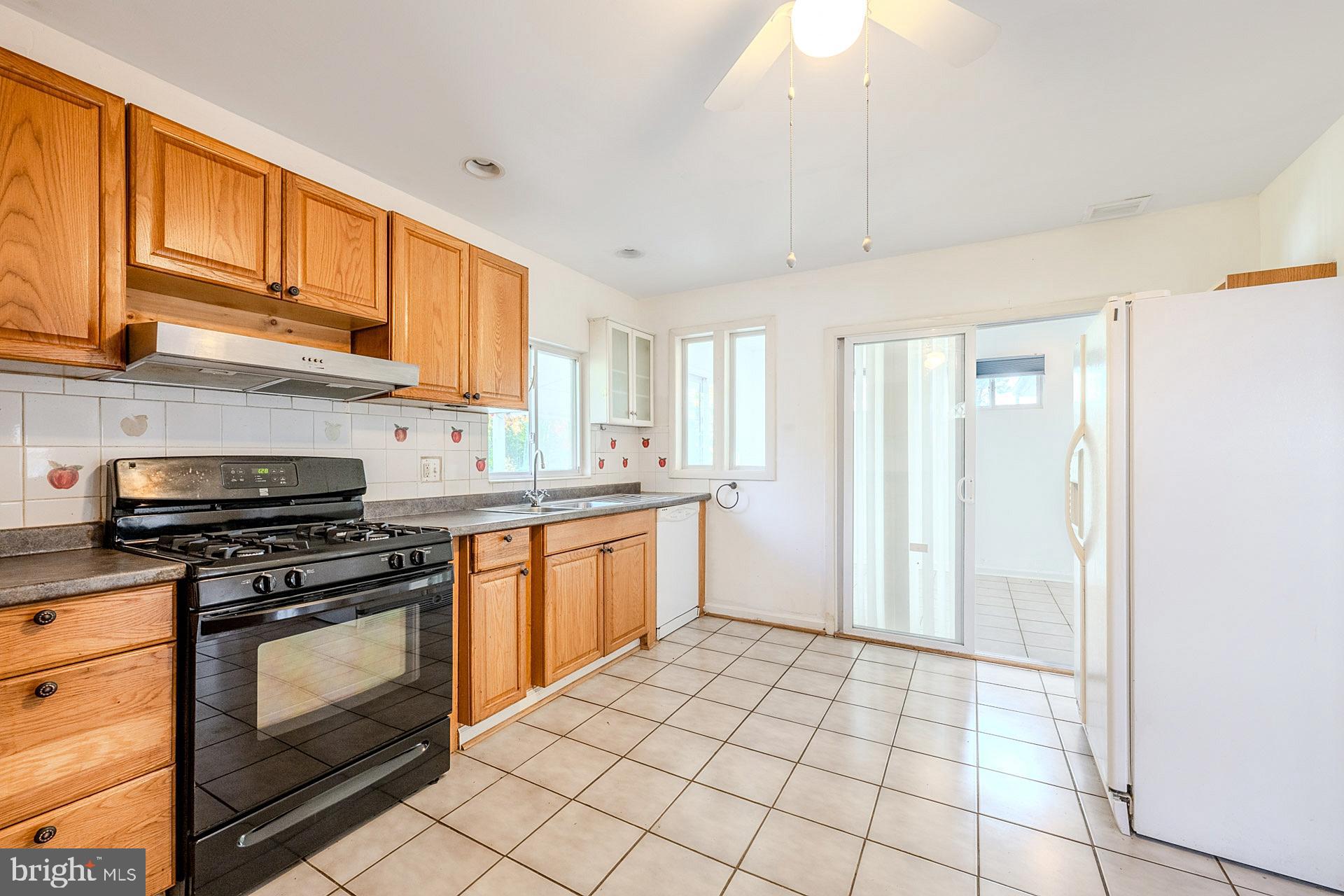 1108 Chickasaw Drive Silver Spring, MD 20903 - Photo 11 of 30 a kitchen with stainless steel appliances granite countertop a stove a sink and a refrigerator