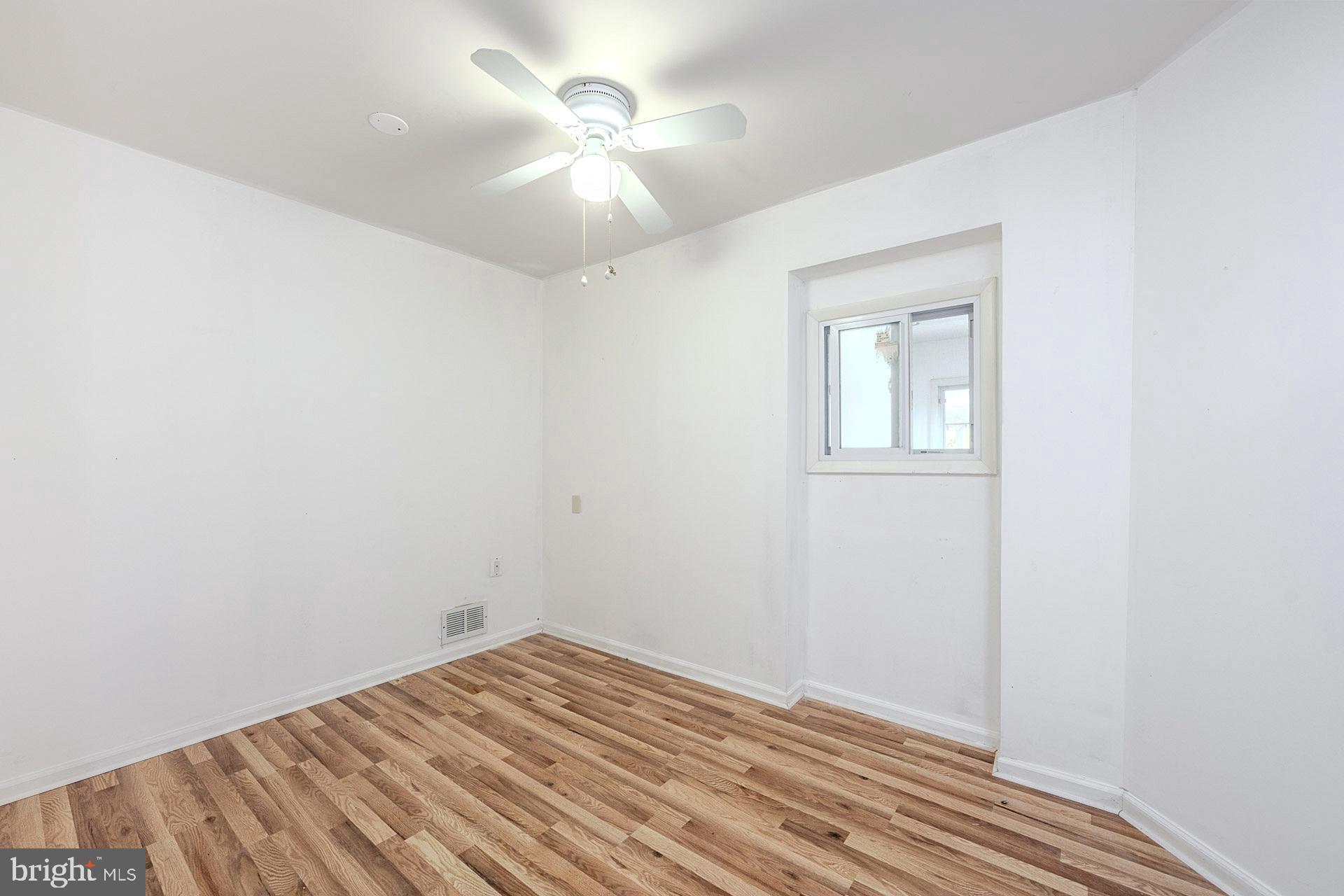 1108 Chickasaw Drive Silver Spring, MD 20903 - Photo 18 of 30 an empty room with a chandelier fan and wooden floor