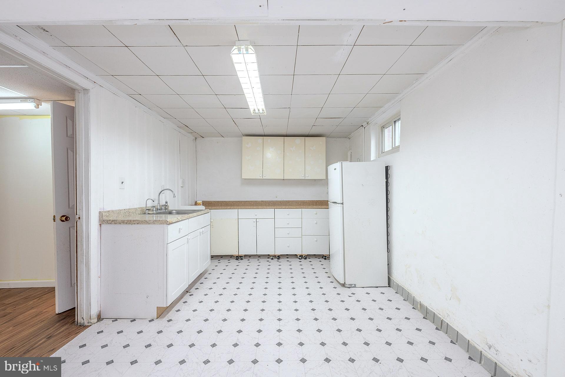 1108 Chickasaw Drive Silver Spring, MD 20903 - Photo 24 of 30 a kitchen with a sink a refrigerator and cabinets