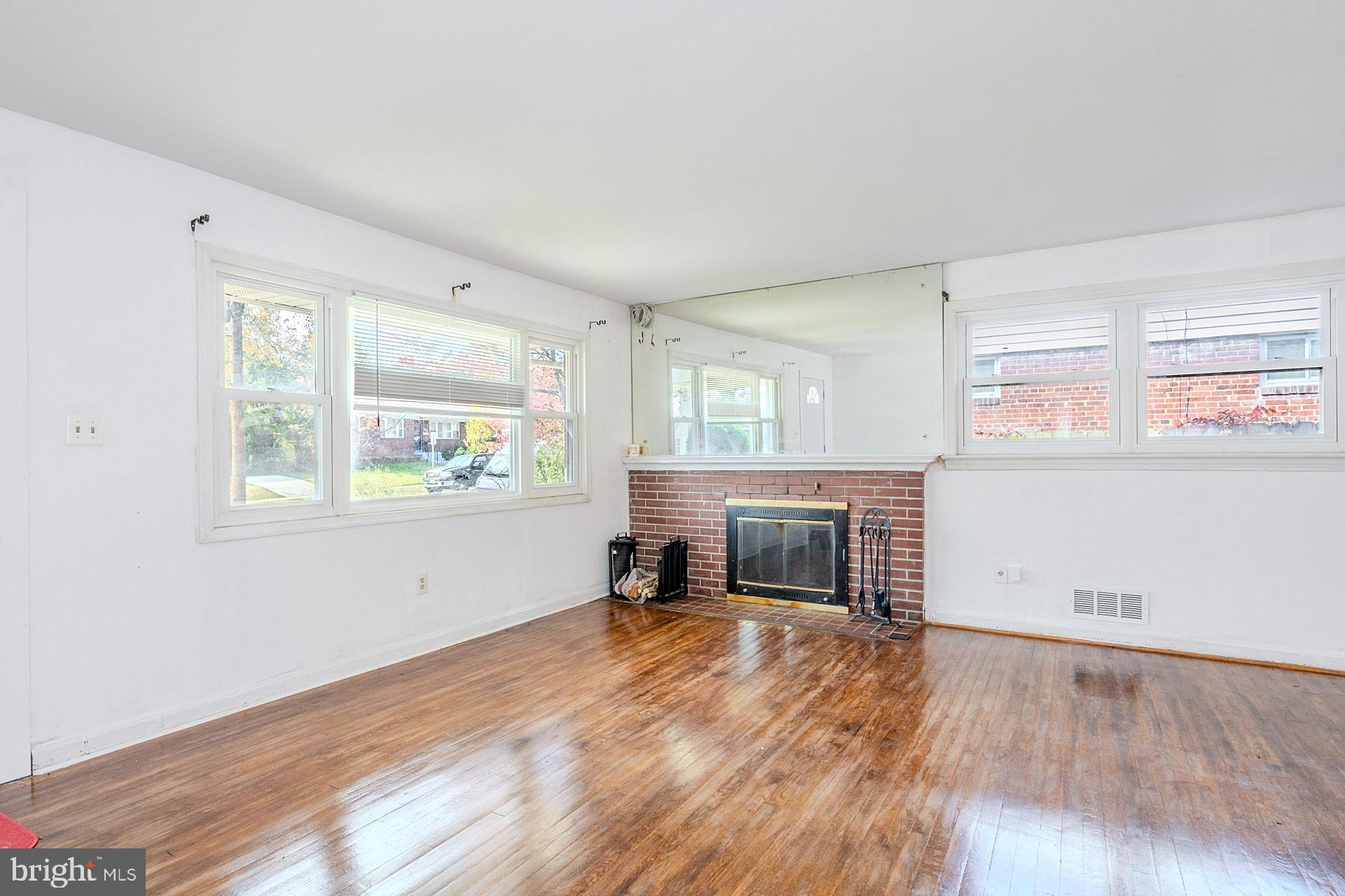 1108 Chickasaw Drive Silver Spring, MD 20903 - Photo 6 of 30 an empty room with windows fireplace and wooden floor