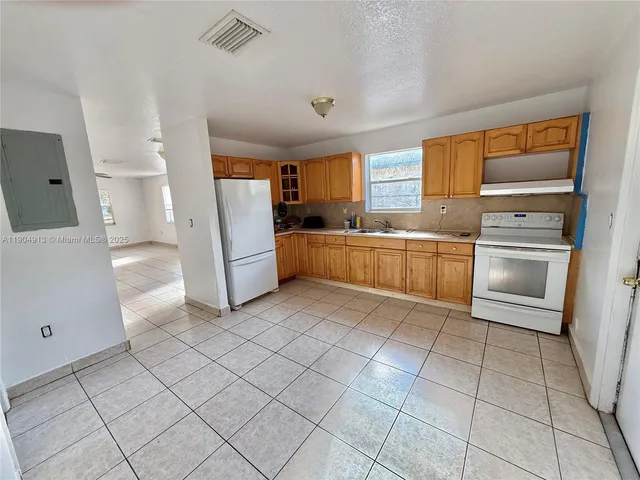 a large kitchen with a stove a refrigerator and a sink