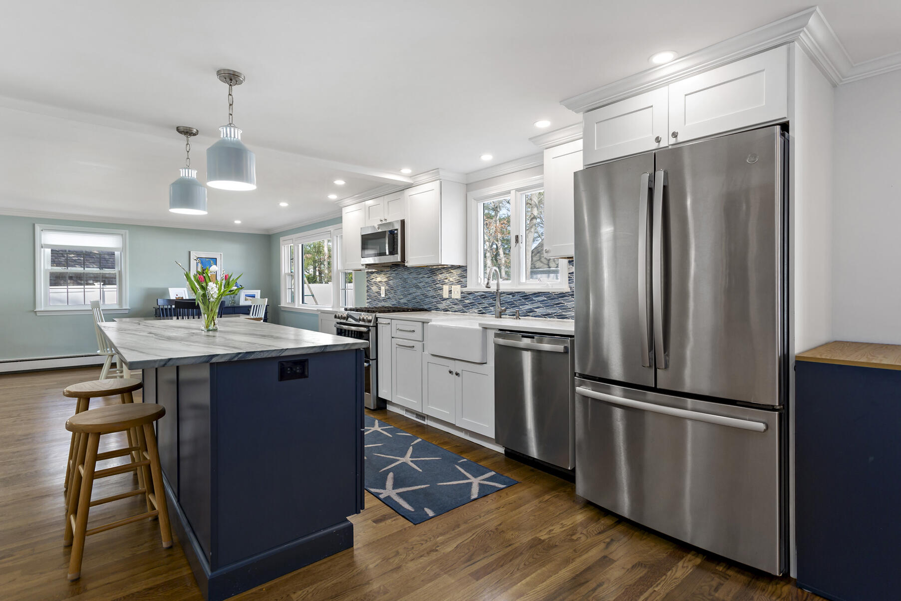 50 Deerfield Road Osterville, MA 02655 - Photo 10 of 32 a kitchen with kitchen island granite countertop wooden floors stainless steel appliances and dining table