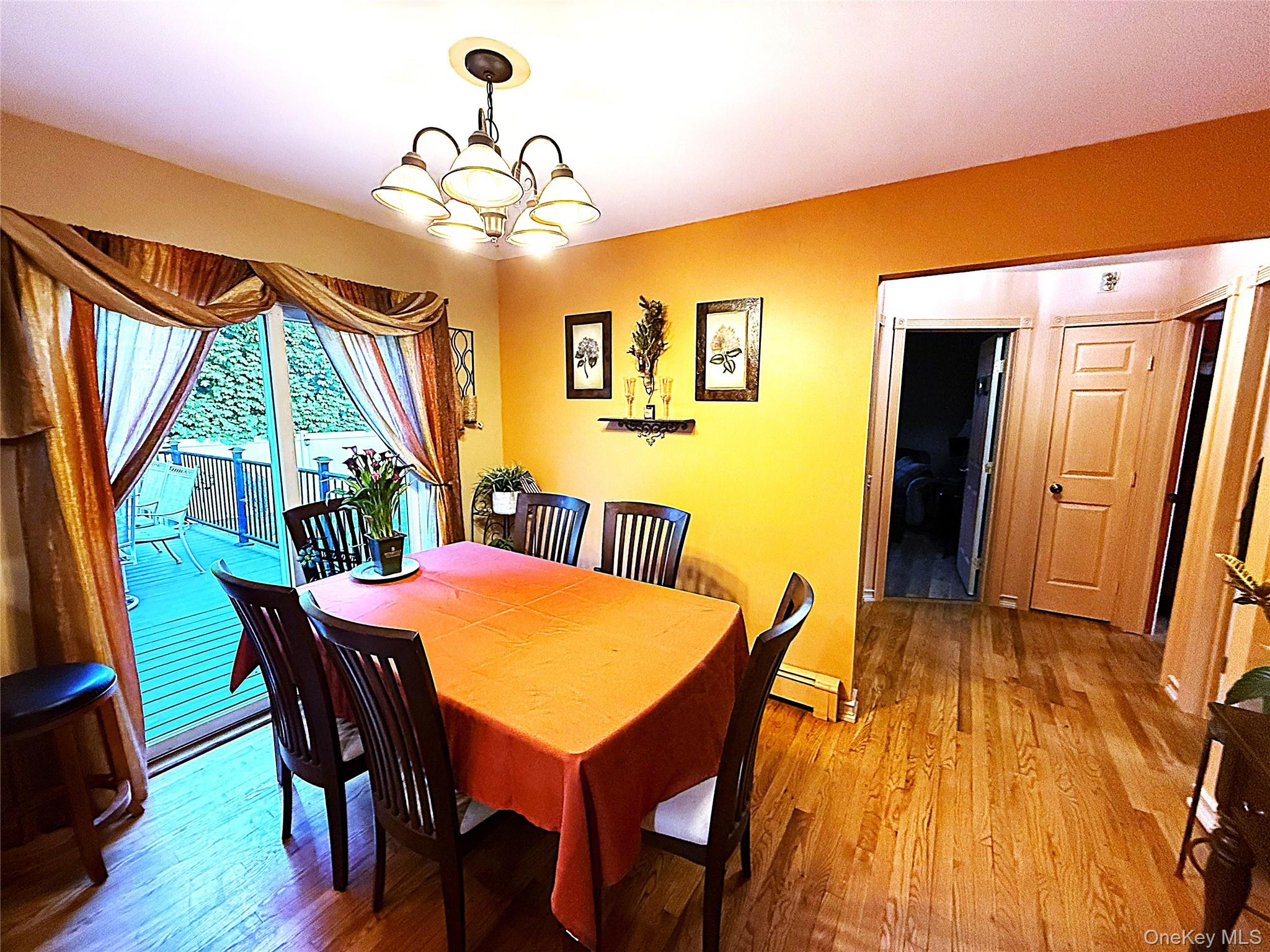1 Heston Road Shirley, NY 11967 - Photo 15 of 32 Interior dining area featuring wood-finish flooring, a multi-light chandelier, and sliding glass doors leading to an exterior deck