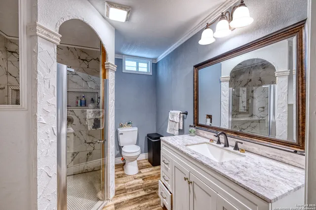 a en suite bathroom with a granite countertop sink mirror and toilet