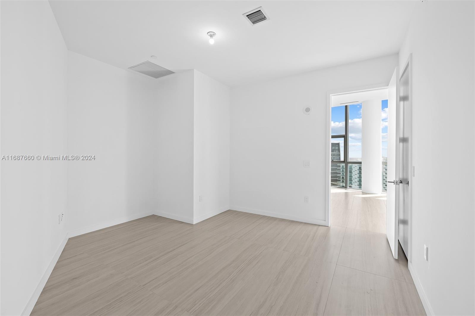 851 Northeast 1st Avenue, Unit PH5700 Miami, FL 33132 - Photo 32 of 91 an empty room with wooden floor and windows