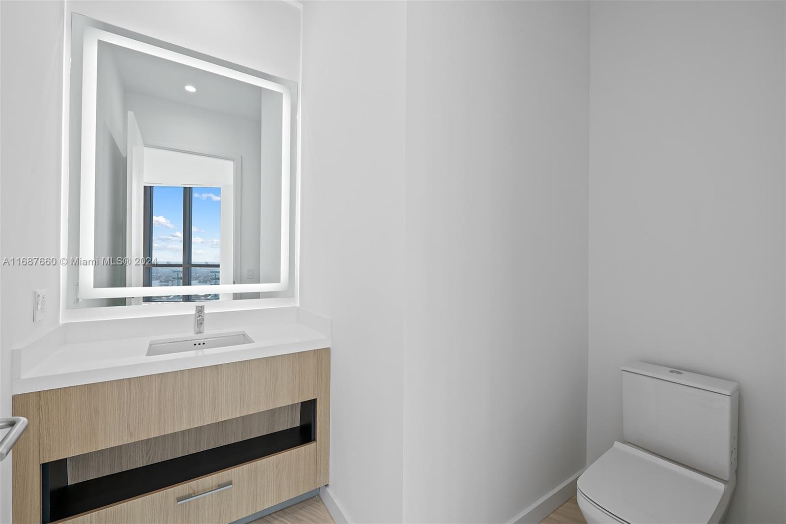 851 Northeast 1st Avenue, Unit PH5700 Miami, FL 33132 - Photo 38 of 91 a bathroom with a toilet sink and mirror