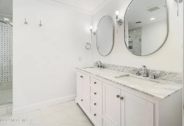 a bathroom with a granite countertop double vanity sink and a mirror